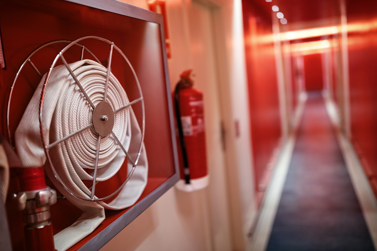 fire hose in a hallway with emergency lighting