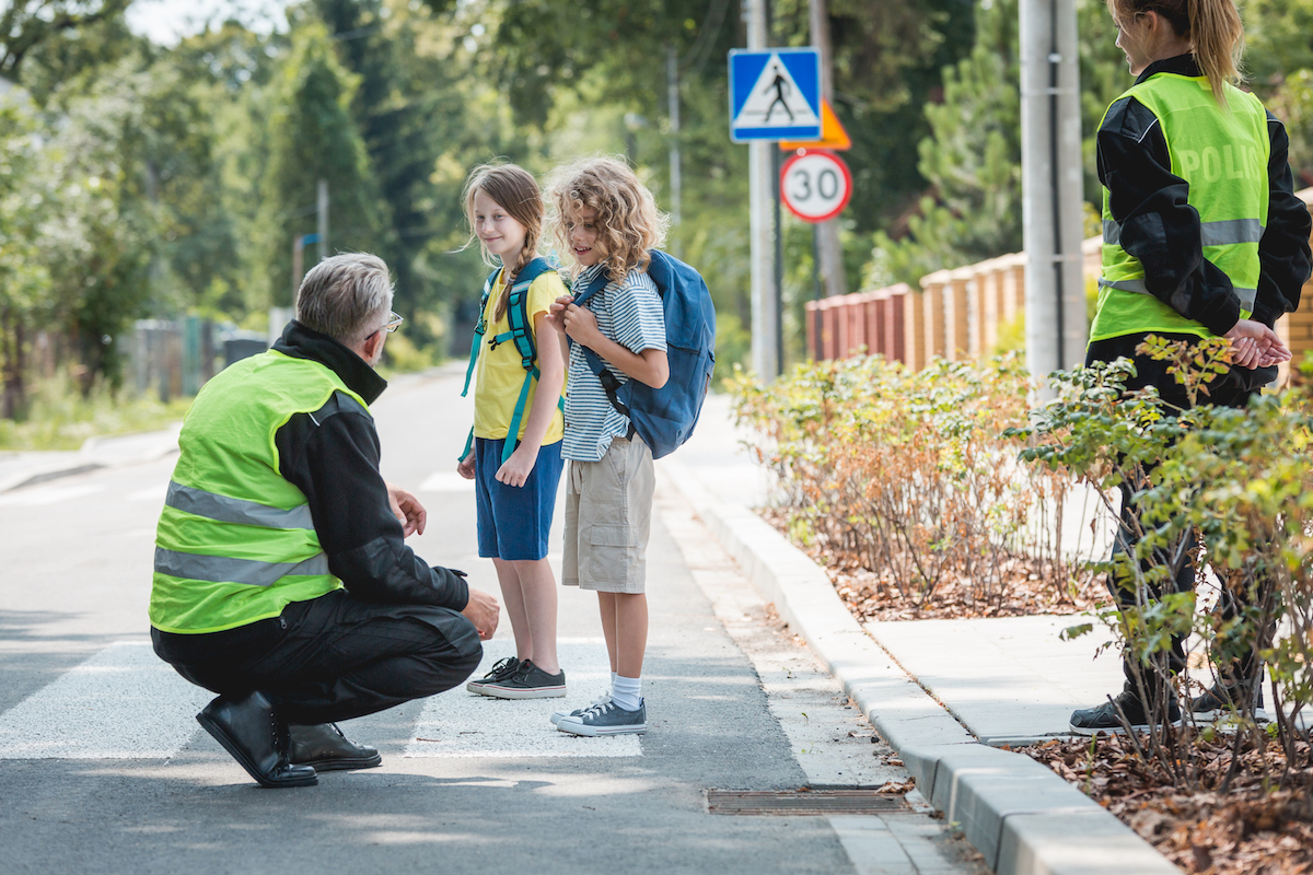 policeman crouching talking to students