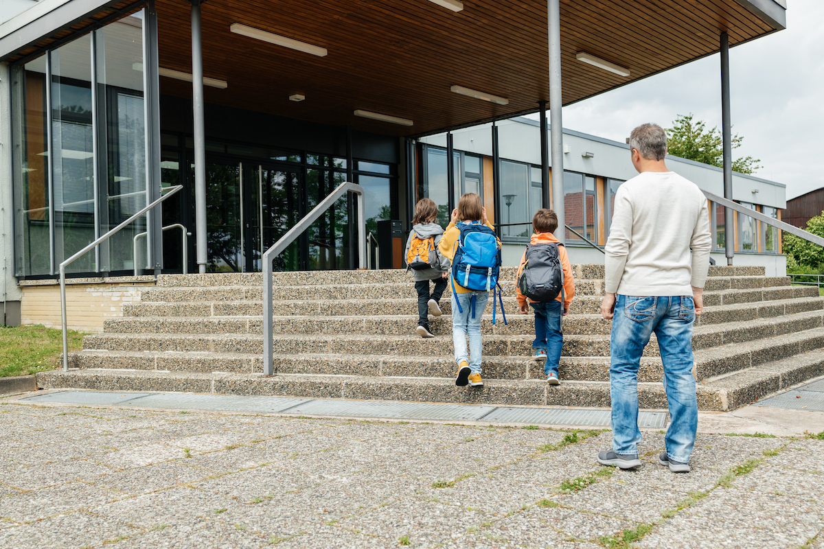 a father walking his kids to school