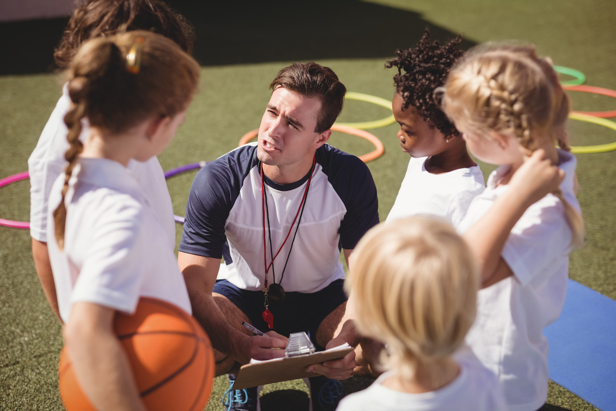 coach discussing with school kids