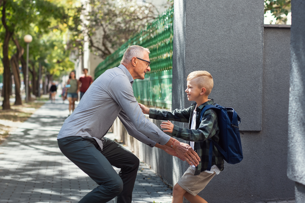 school boy running to meet his grandfather