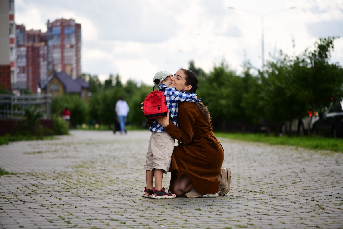 mother embracing son during school pick up