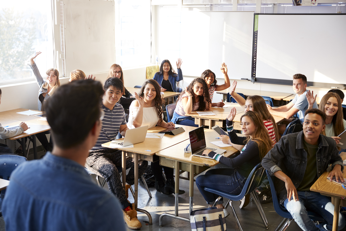 middle school teacher teaching a classroom full of students