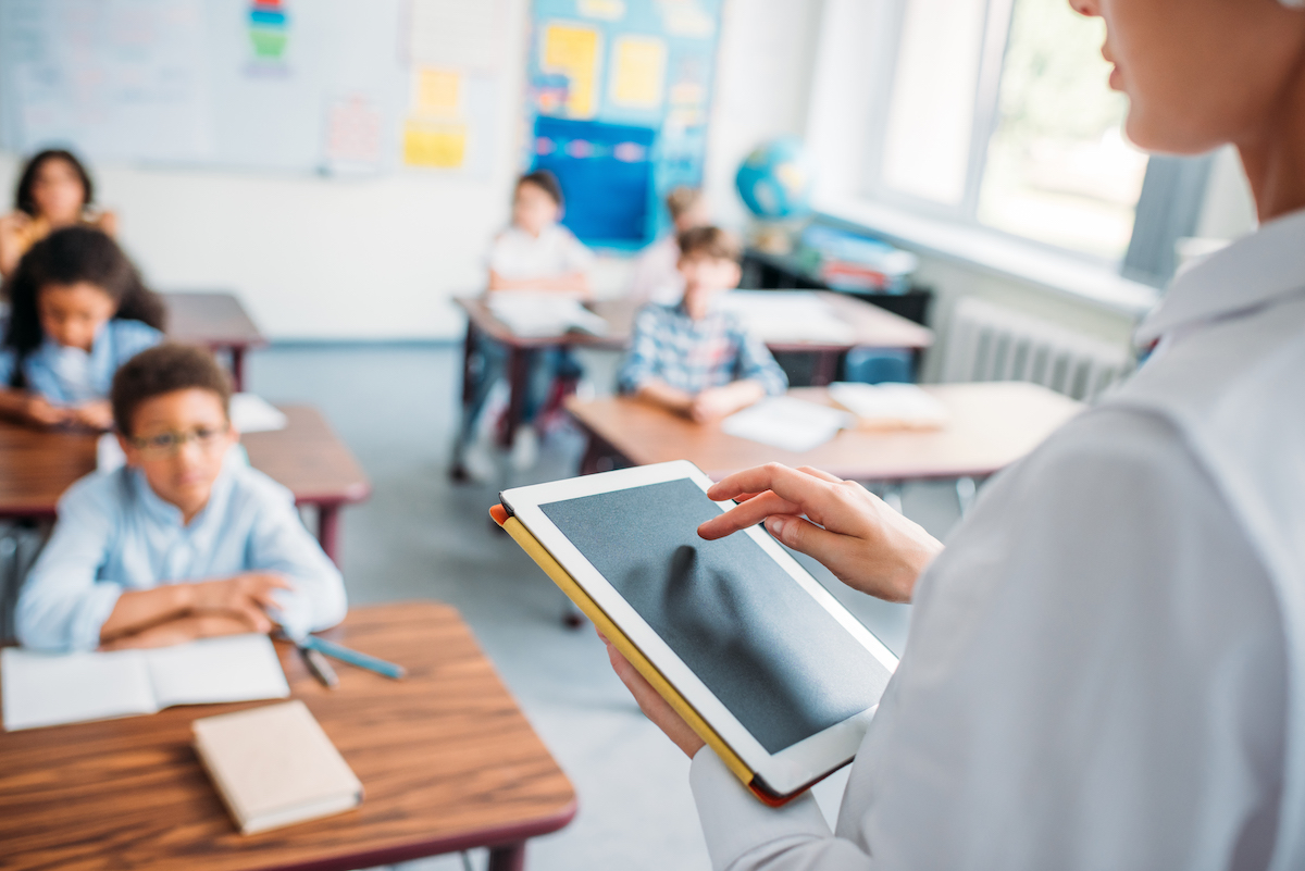 teacher using a tablet in a classroom