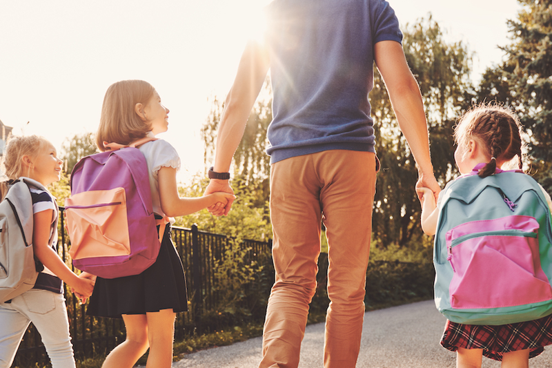 parent and children walking to school