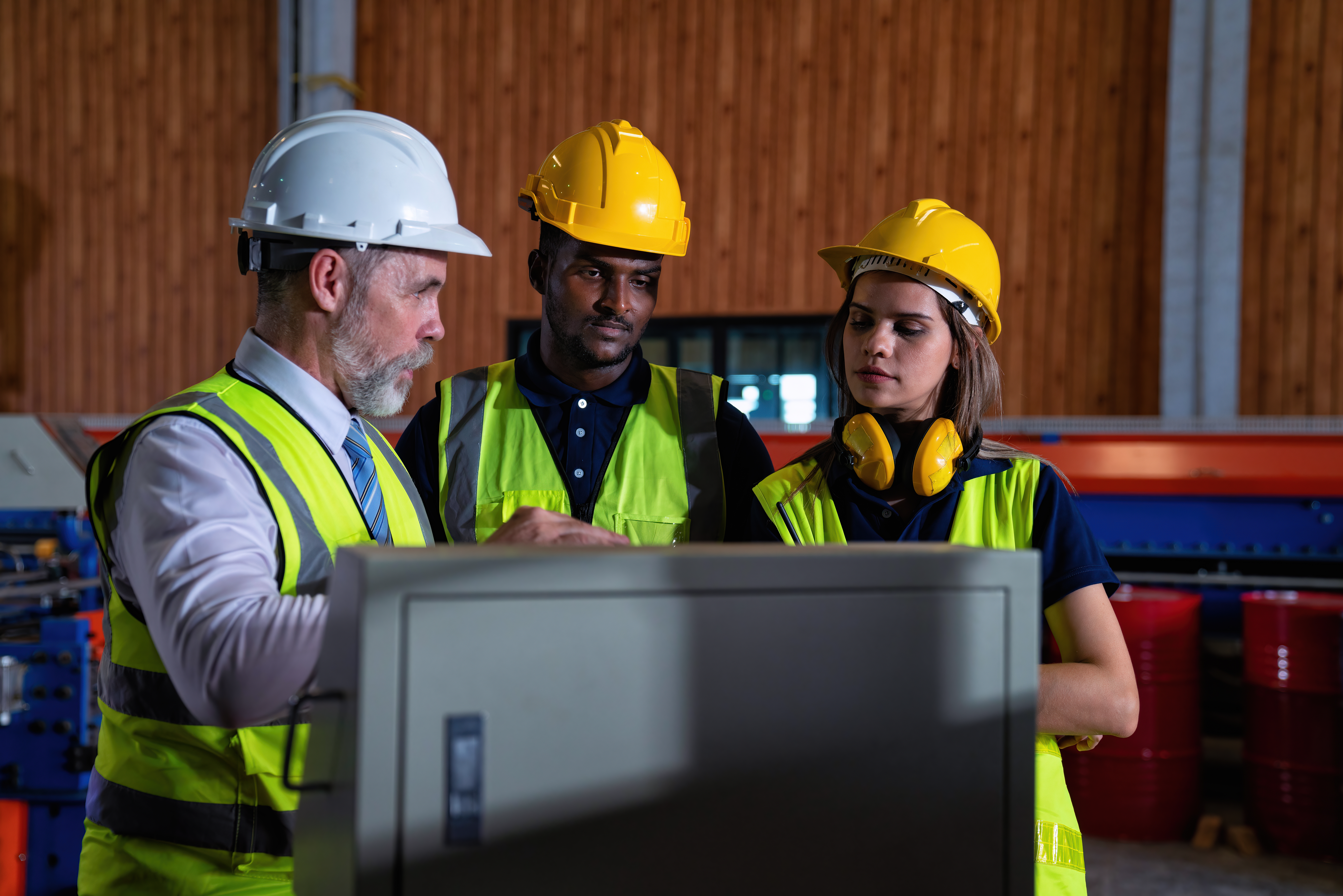 three workers talking about workplace safety in hard hats